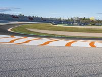 the green road and orange and white stripe line at an event near the racetrack and stadium