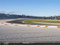 the green road and orange and white stripe line at an event near the racetrack and stadium