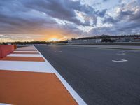 sunset on an orange and white checkered racing track in the middle of a parking lot