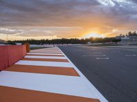 sunset on an orange and white checkered racing track in the middle of a parking lot