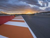 sunset on an orange and white checkered racing track in the middle of a parking lot