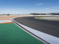 the green road and orange and white stripe line at an event near the racetrack and stadium