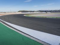 the green road and orange and white stripe line at an event near the racetrack and stadium