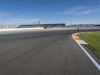 the green road and orange and white stripe line at an event near the racetrack and stadium