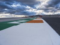 there is a colorful road on this side of the street on the race track under cloudy skies