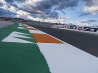 there is a colorful road on this side of the street on the race track under cloudy skies