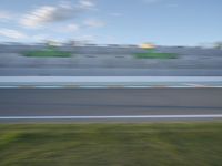 a motion blurred image of a car driving around a track in an open area with spectators