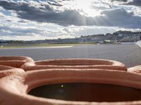 orange rubber hot dogs sit in front of a runway at an airport during the day