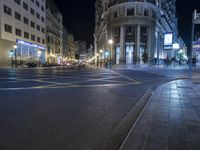 an empty city street at night with traffic light traffic visible on the street and buildings