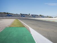 the green road and orange and white stripe line at an event near the racetrack and stadium