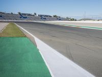 the green road and orange and white stripe line at an event near the racetrack and stadium