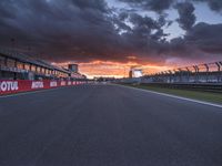 a sun is rising over the racing track during sunset on a cloudy day and is set