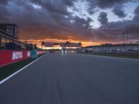 a sun is rising over the racing track during sunset on a cloudy day and is set