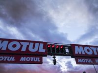 a red sign for motor motel at dusk with a blue sky in the background and dark clouds above