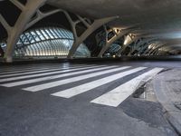 people are crossing the street on a crosswalk in an empty area of city hall