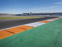 the green road and orange and white stripe line at an event near the racetrack and stadium