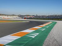 the green road and orange and white stripe line at an event near the racetrack and stadium