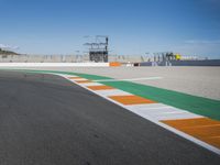 the green road and orange and white stripe line at an event near the racetrack and stadium