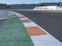 the green road and orange and white stripe line at an event near the racetrack and stadium