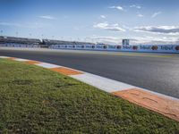 the green road and orange and white stripe line at an event near the racetrack and stadium