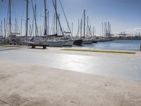 there is a boat dock where many boats are docked and one is empty in the water