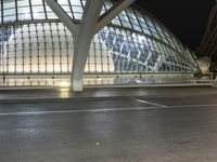 a bus stop with lots of people on the street in front of it and a glass dome