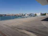 the roof of a large building has a beautiful view over a harbor and its surrounding deck