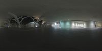 a circular view looking down an airport walkway at night or day, to the left of the terminal