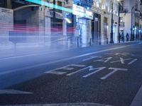 an image of a street at night with the word start painted on it and blurry traffic