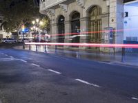 an empty road with a car turning red and light trails showing that motion is changing