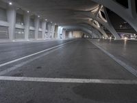 the view from the inside of a large building, with concrete pillars and columns, at night