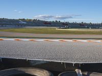 the green road and orange and white stripe line at an event near the racetrack and stadium