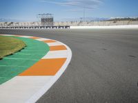 the green road and orange and white stripe line at an event near the racetrack and stadium