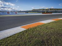 the green road and orange and white stripe line at an event near the racetrack and stadium