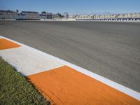 the green road and orange and white stripe line at an event near the racetrack and stadium