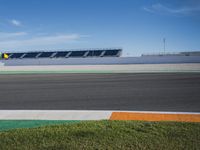 the green road and orange and white stripe line at an event near the racetrack and stadium