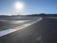 the green road and orange and white stripe line at an event near the racetrack and stadium