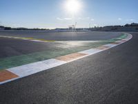 the green road and orange and white stripe line at an event near the racetrack and stadium