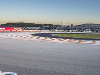 a motorcycle in an empty racing track at sunset time on a sunny day with a few spectators