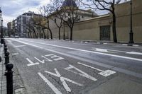 a person is crossing the street in front of an old building and cars on the street