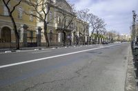 a person is crossing the street in front of an old building and cars on the street