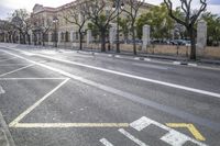 a person is crossing the street in front of an old building and cars on the street