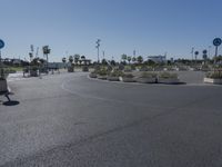 a wide paved street that is lined with many signs and bushes in the middle of it