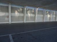 a view of a bench and several windows from inside a building, a red fire hydrant sitting beside it