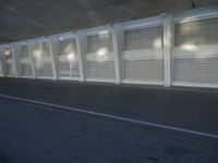 a view of a bench and several windows from inside a building, a red fire hydrant sitting beside it
