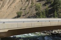 a van crossing over a large road bridge by a mountain stream in the country side