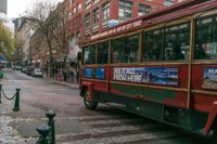 a red double decker bus with the number 53 on it is parked on the street by the curb