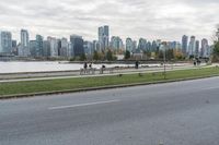 a paved road next to the edge of a lake with a snow - capped mountain