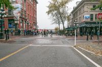 a sidewalk with pedestrians and walking people in it on a rainy day near some tall buildings