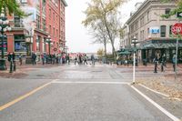 a sidewalk with pedestrians and walking people in it on a rainy day near some tall buildings